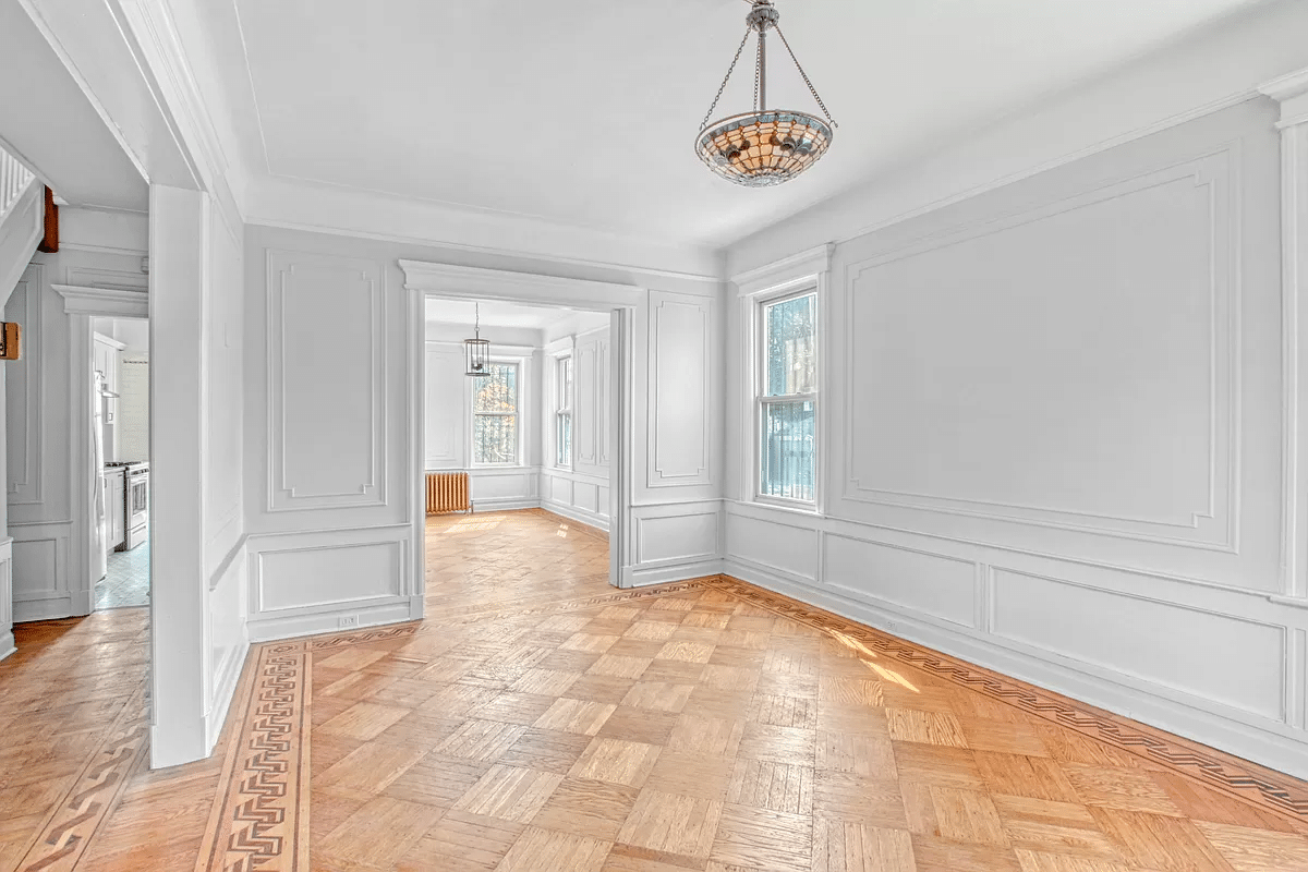 parlor with wall moldings, wood floor