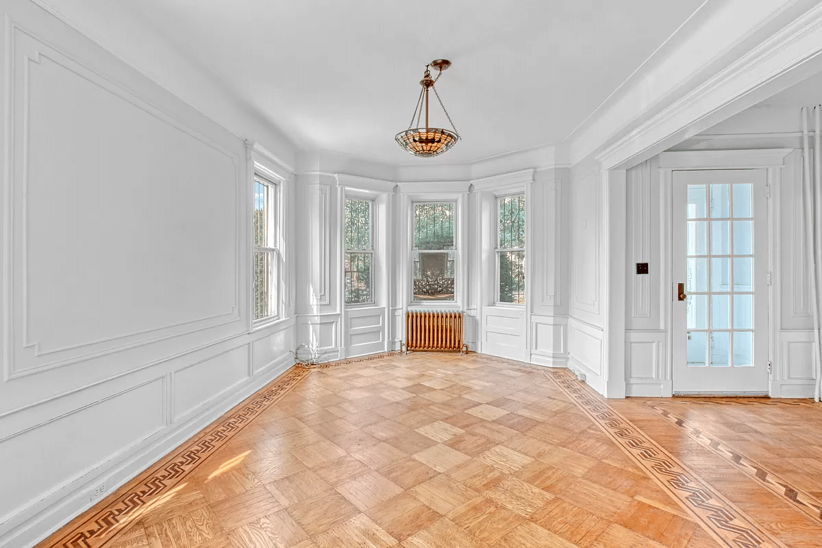 parlor with view of vestibule, wood floor, wall moldings
