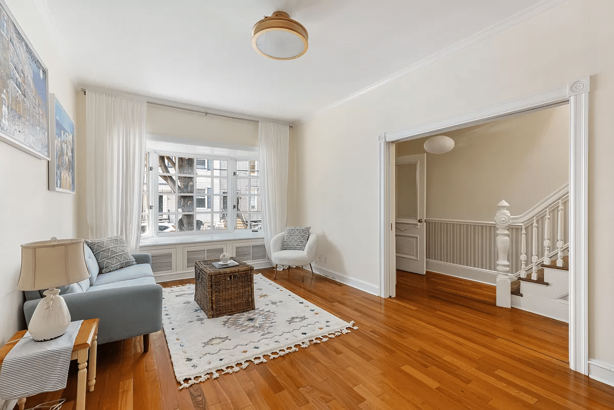 living room with wood floor, view into stair hall