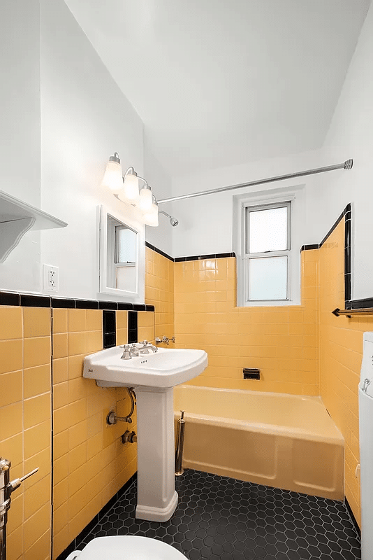 bathroom with yellow wall tile and tub
