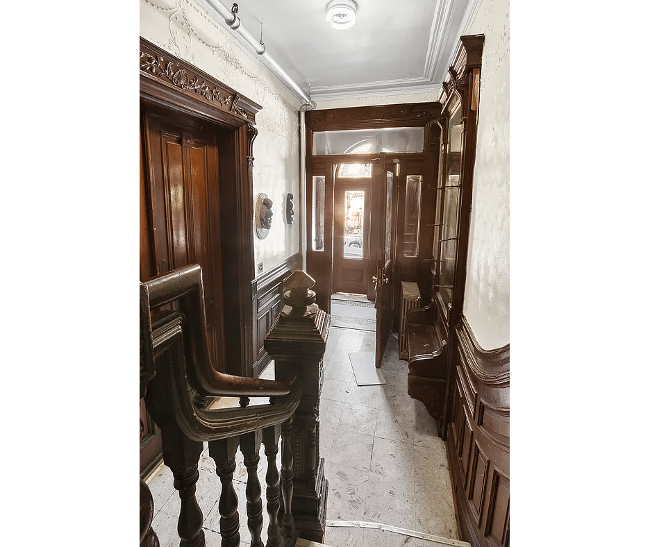 bed stuy - entry with wainscoting, stair, mirror