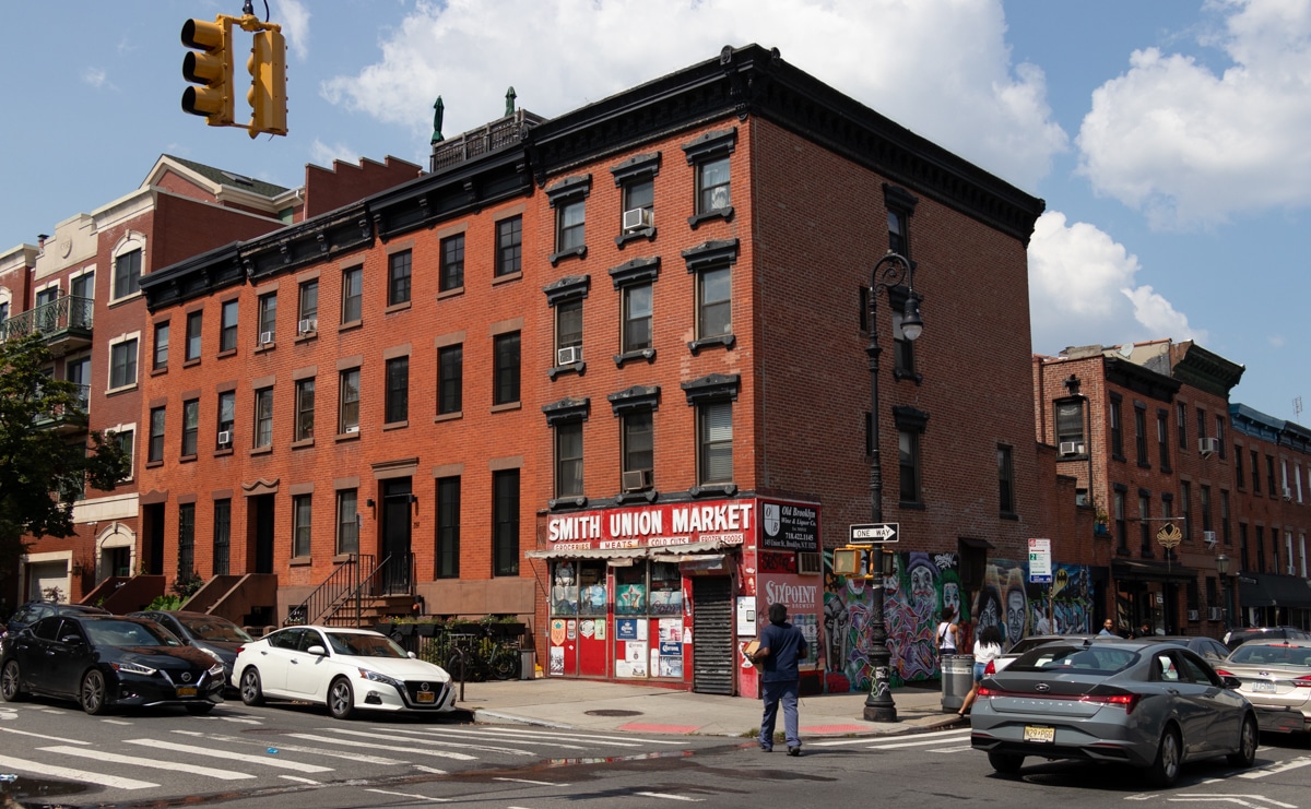 brooklyn - traffic and pedestrians on smith street with brick row houses in the background and smith union market