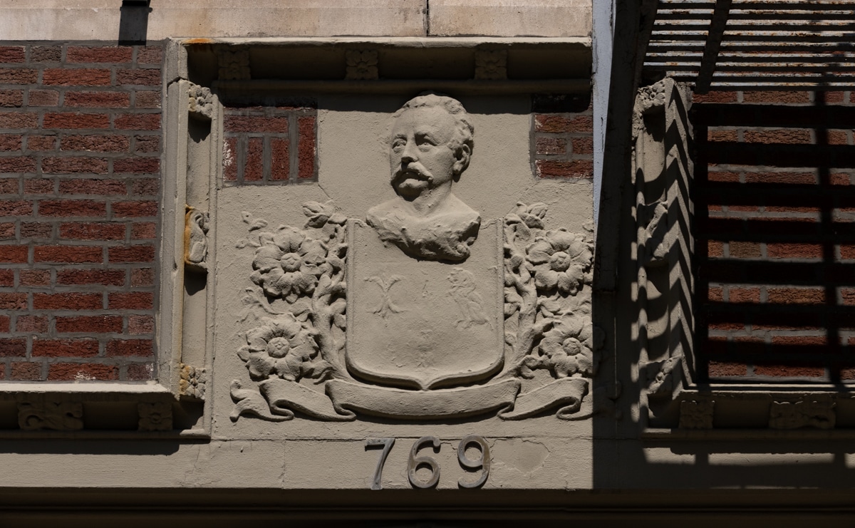 brooklyn - a bas relief above an apartment doorway with the face of a man and flowers