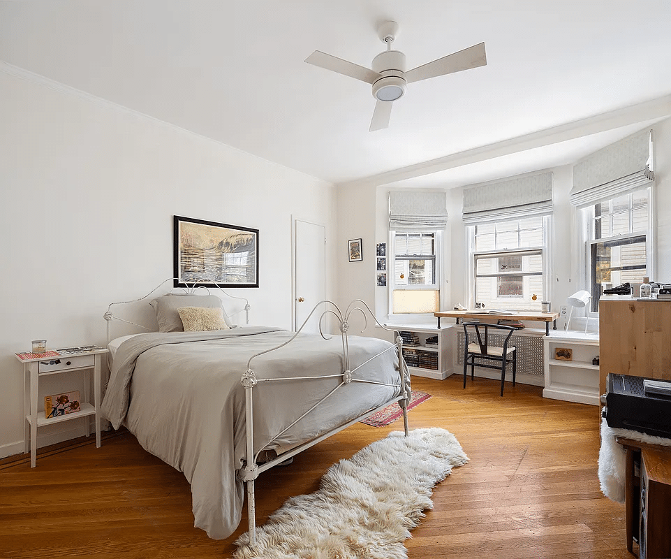bedroom with bay window, ceiling fan, wood floor