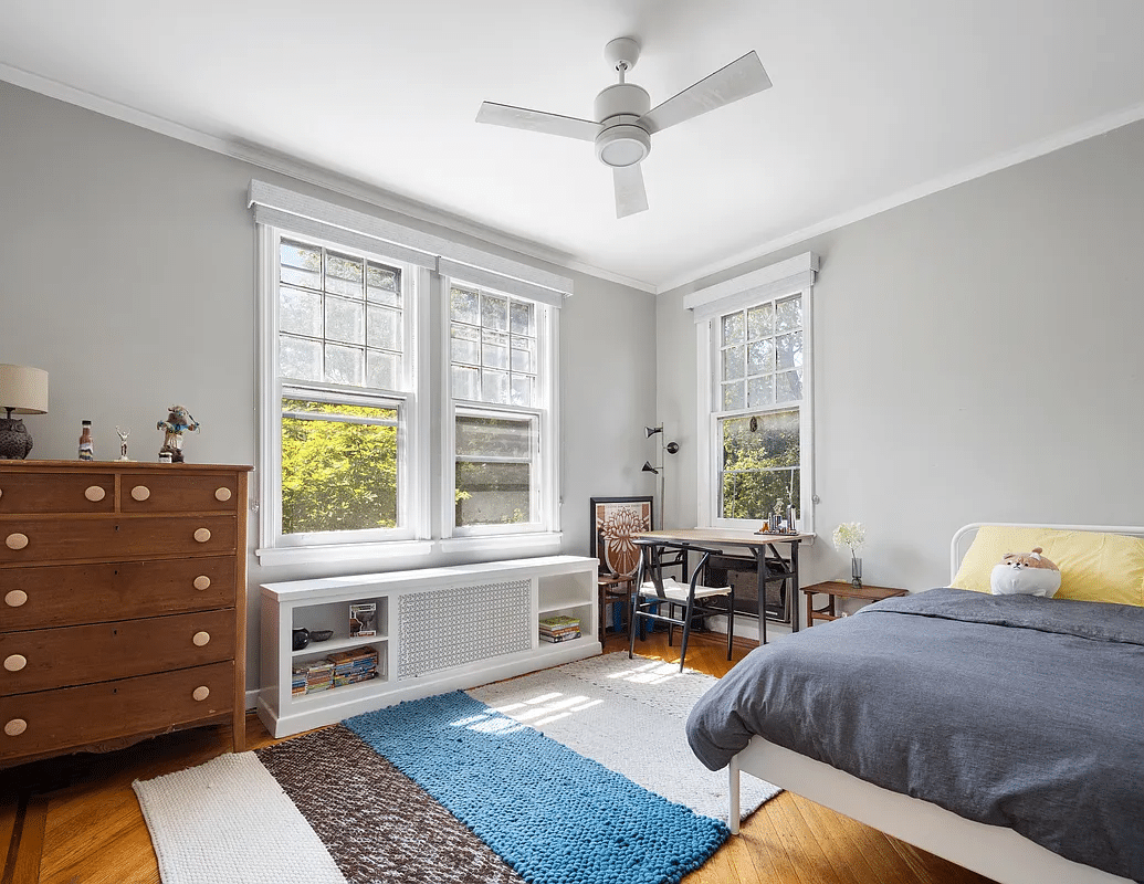 bedroom with two exposures, ceiling fan and wood floor