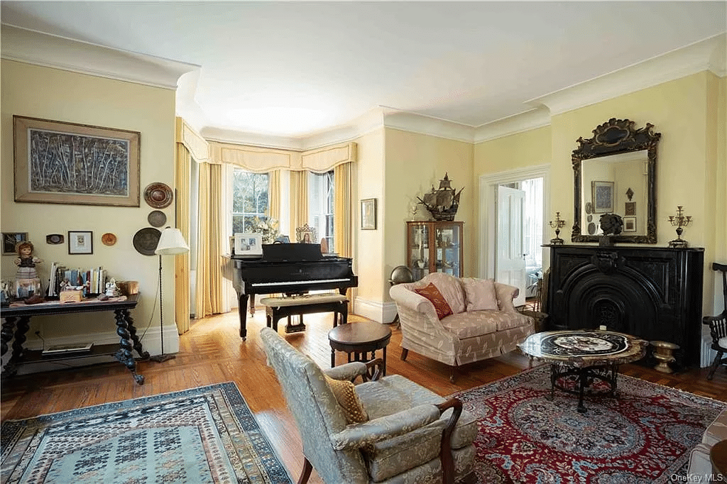 parlor with black marble mantel, wood floor