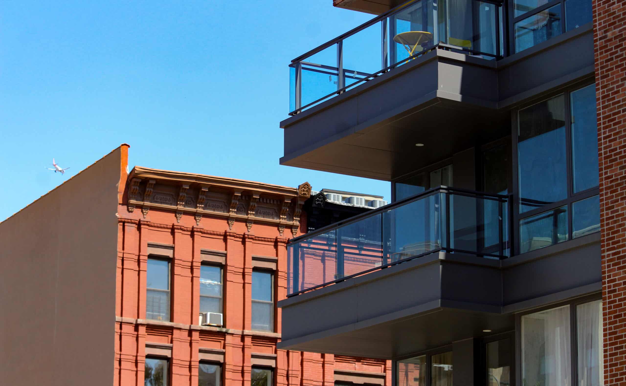 brooklyn - balconies of a modern building in bed stuy in front of rowhouses