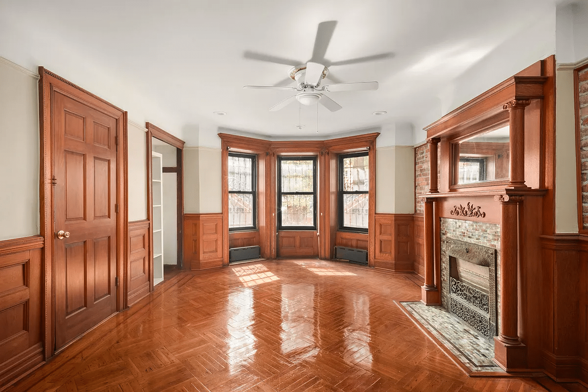 former dining room with wainscoting, mantel with mirror