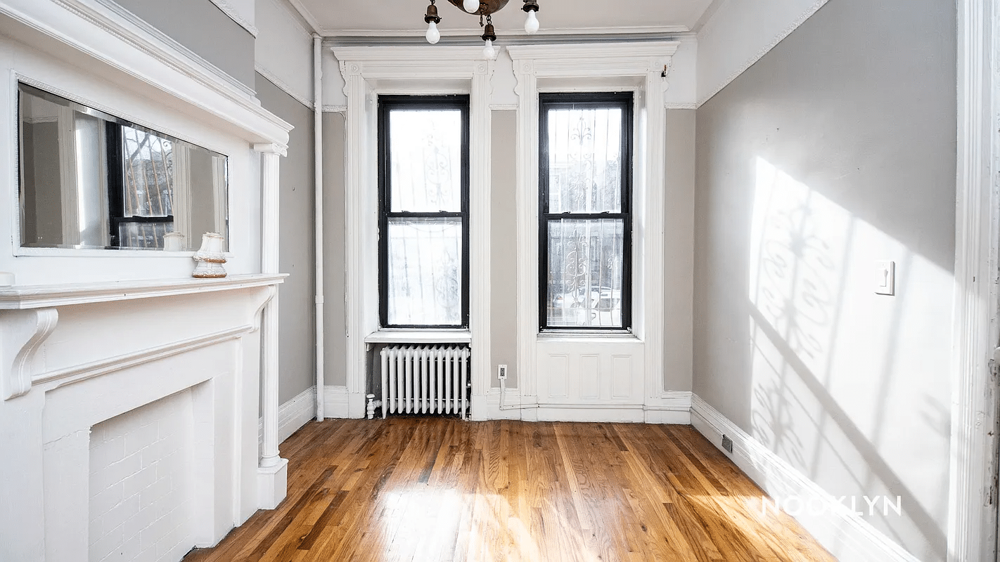 room with white painted mantel, two windows, chandelier