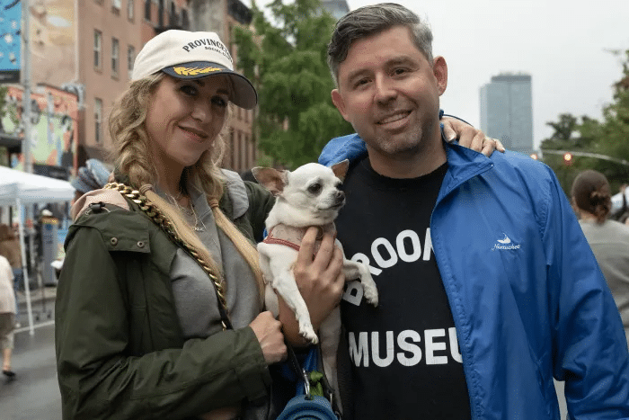 people posing with a tiny dog