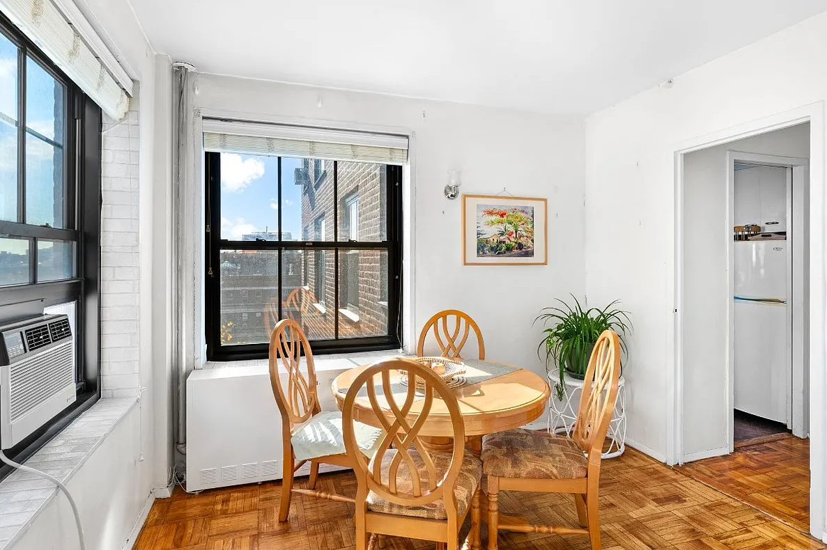 dining nook with parquet floor and two exposures and view into kitchen hall