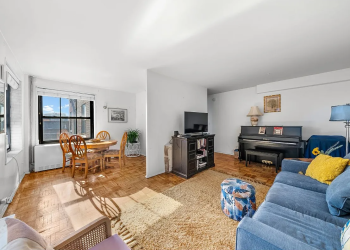 living room with parquet floors and view into dining nook