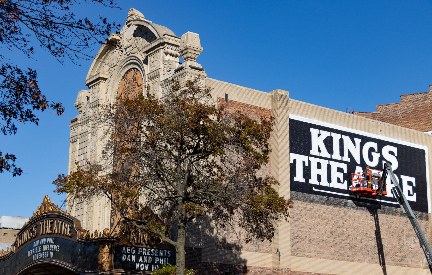 brooklyn - sign painters at work on a Kings Theatre sign on the side of the building