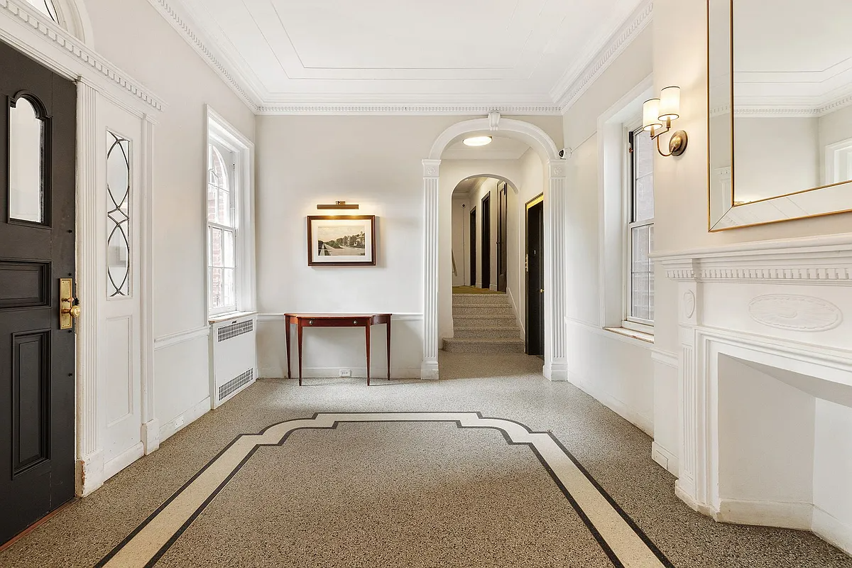 Colonial Revival style building lobby with a white mantel and arched doorways
