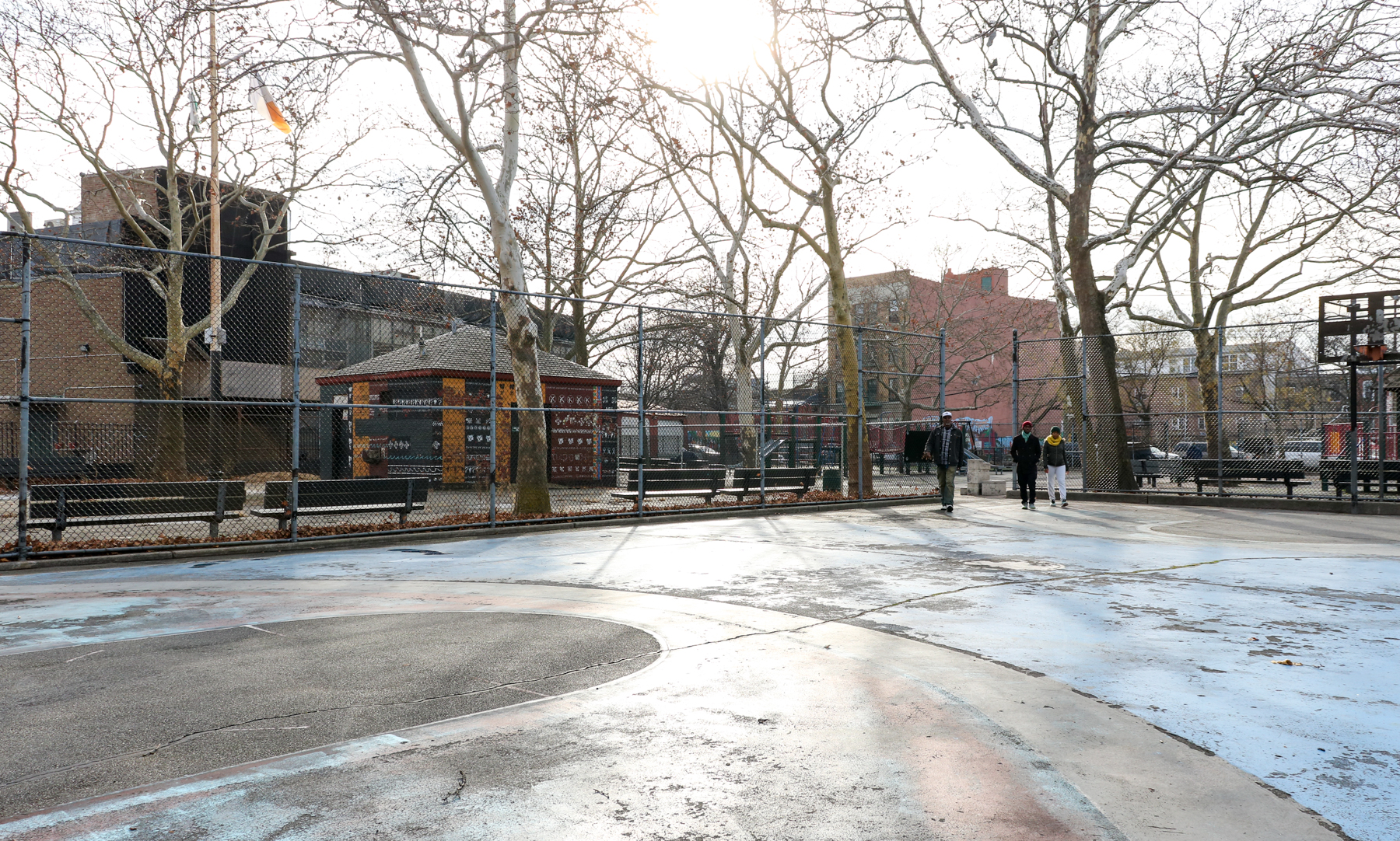 view of basketball court with benches and park beyond