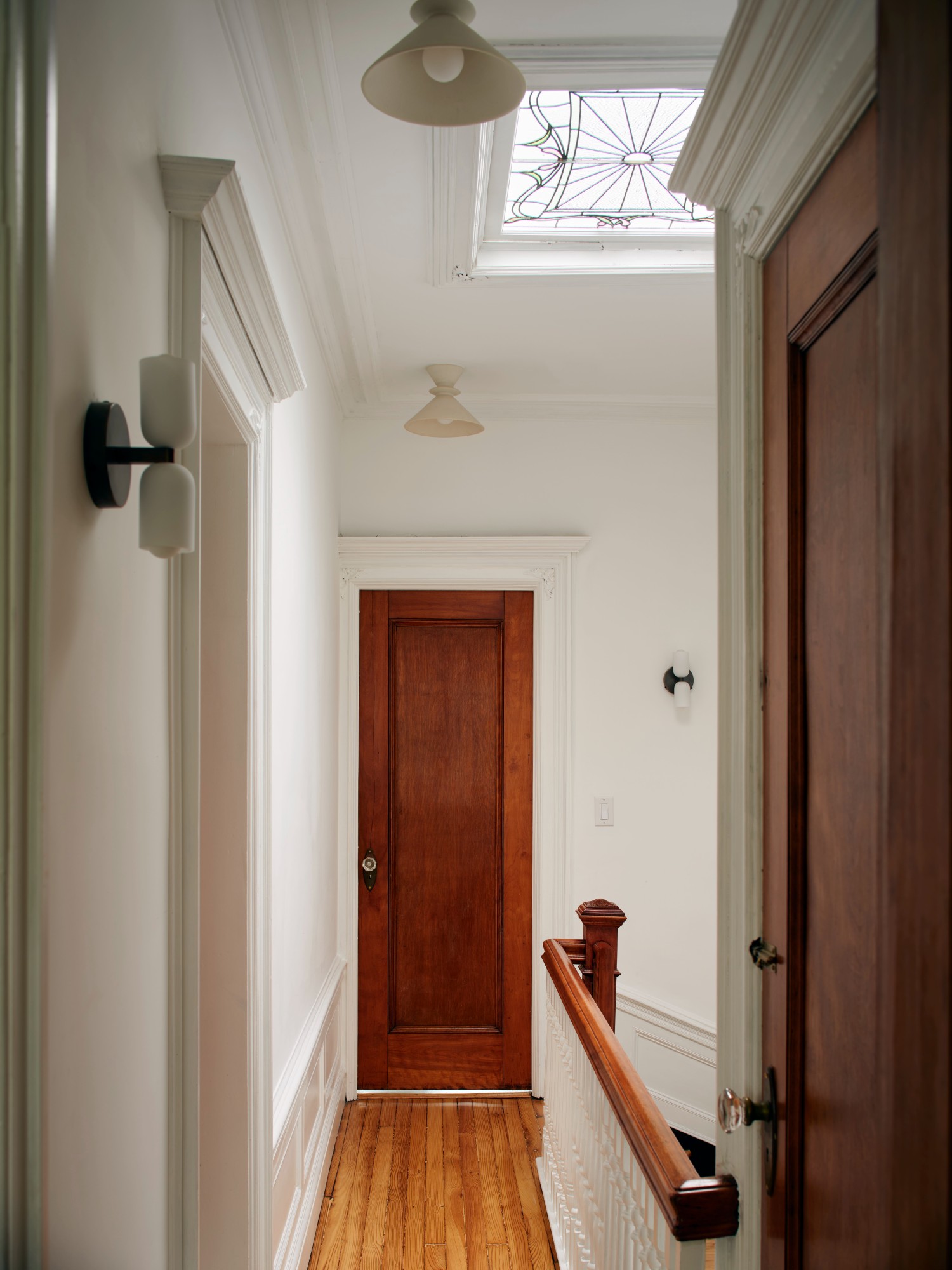 TOP FLOOR HALL WITH RED DOOR AND SKYLIGHT