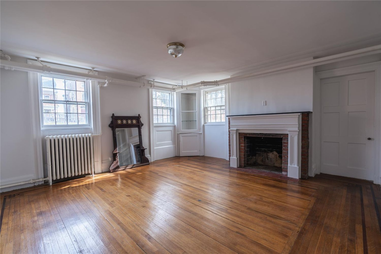 lower apartment living room with mantel, corner built-in, wood floor