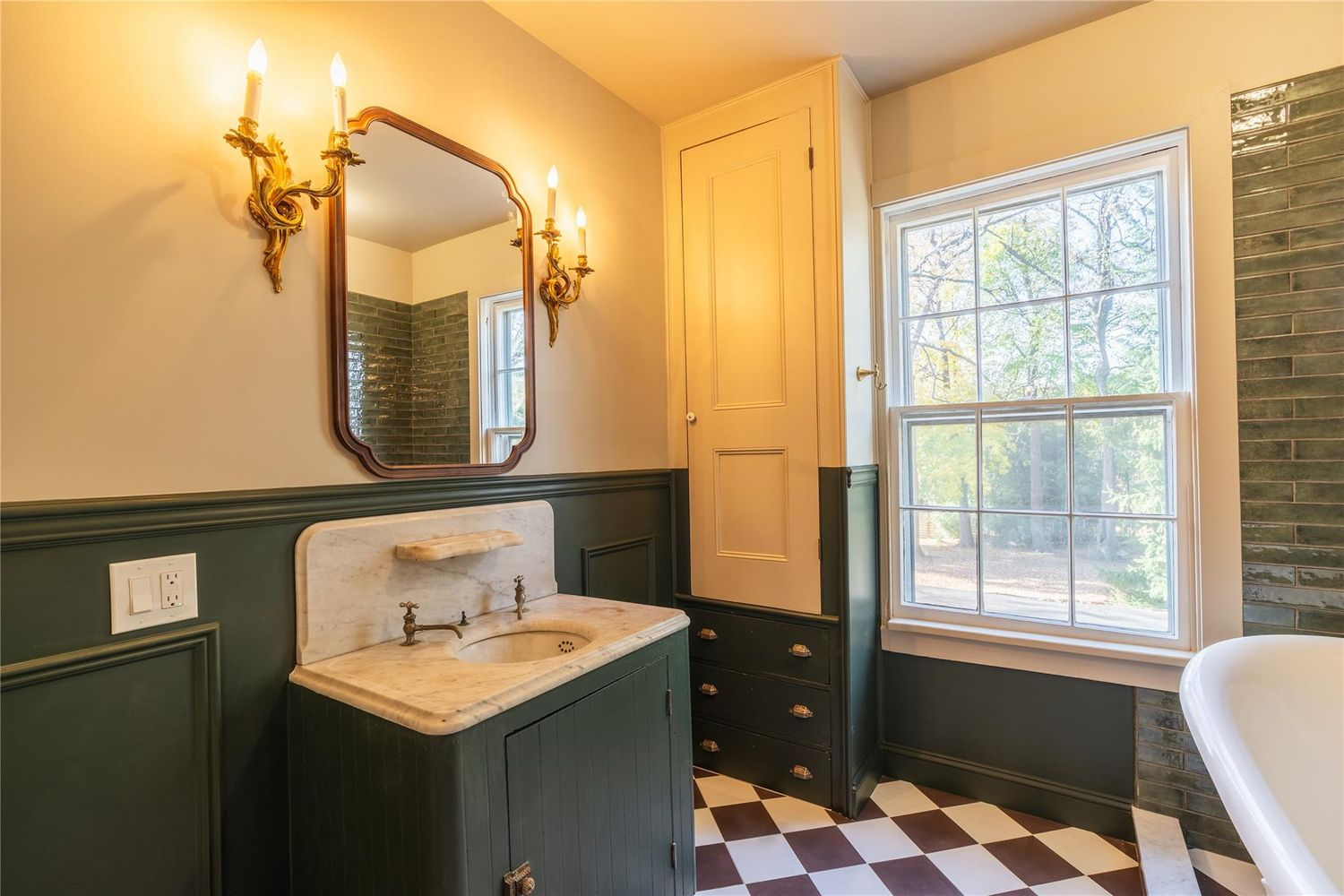 bathroom with checkerboard floor, wainscoting, tub