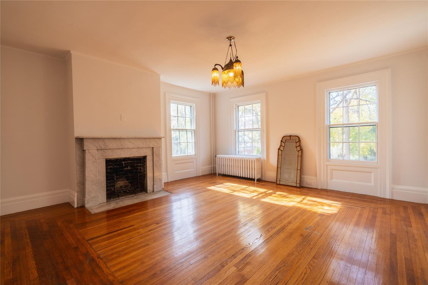 bedroom with marble mantel, wood floor, two exposures
