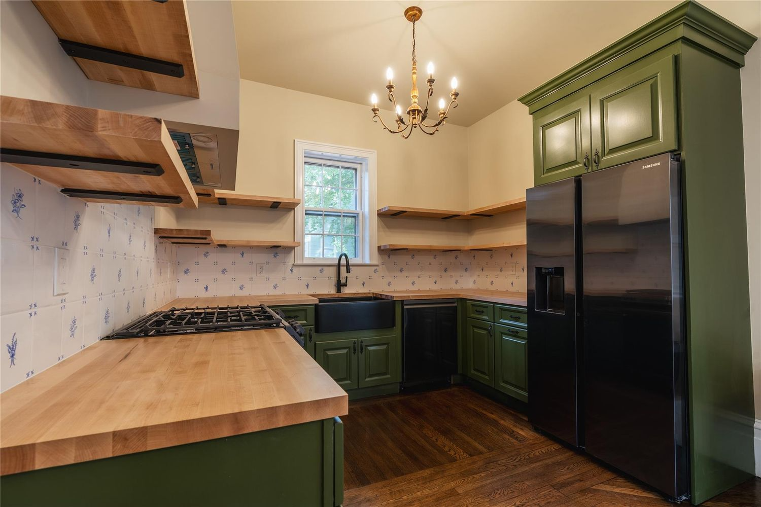 kitchen with green cabinets, blue and white tile backsplash
