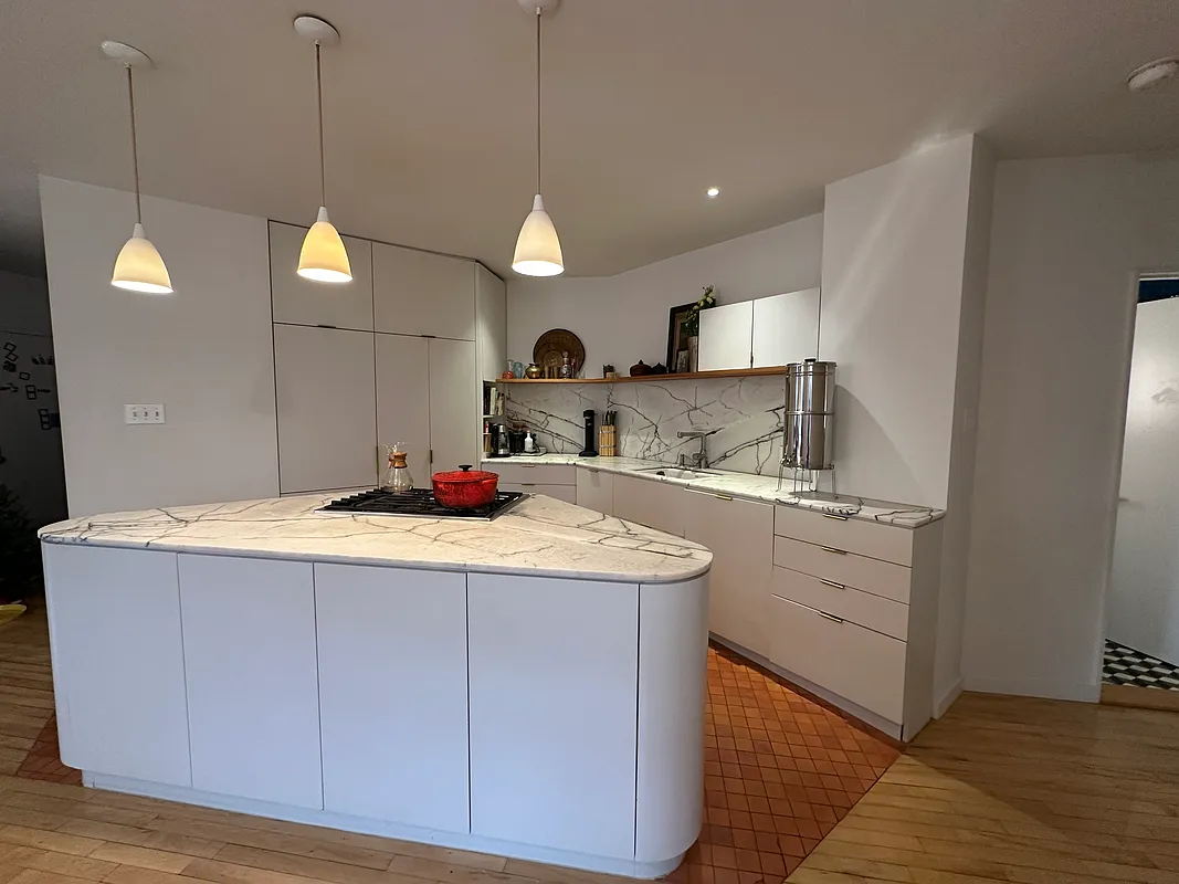 kitchen with white cabinets, triangular island