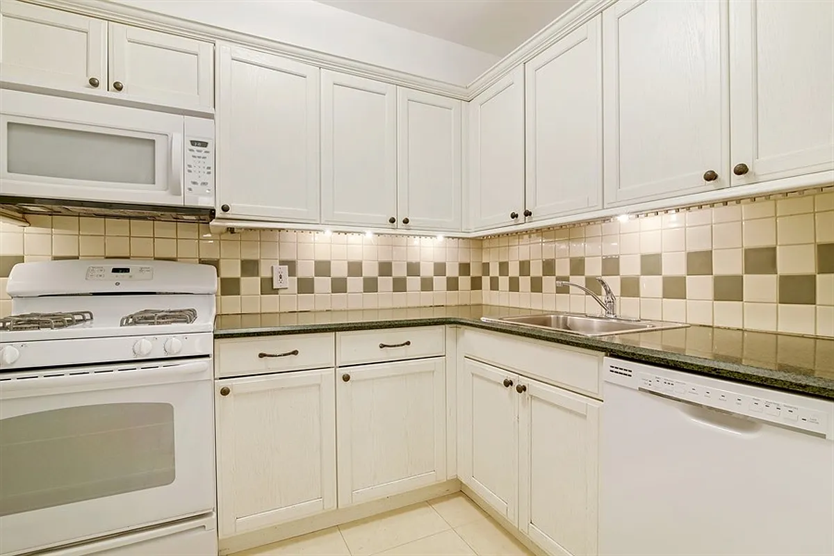 kitchen with white cabinets and appliances, including a dishwasher
