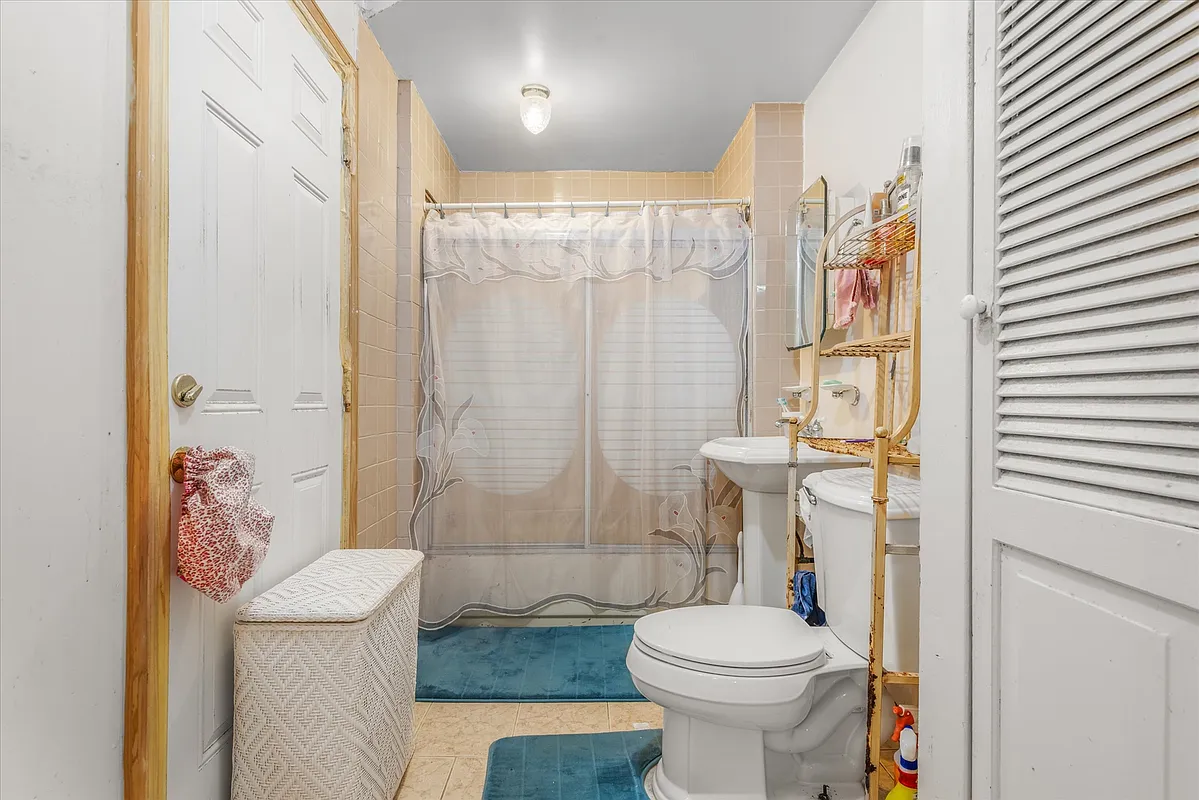 bathroom with white fixtures, beige tile