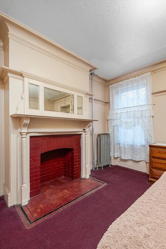 bedroom with mantel with mirror, wall to wall carpet