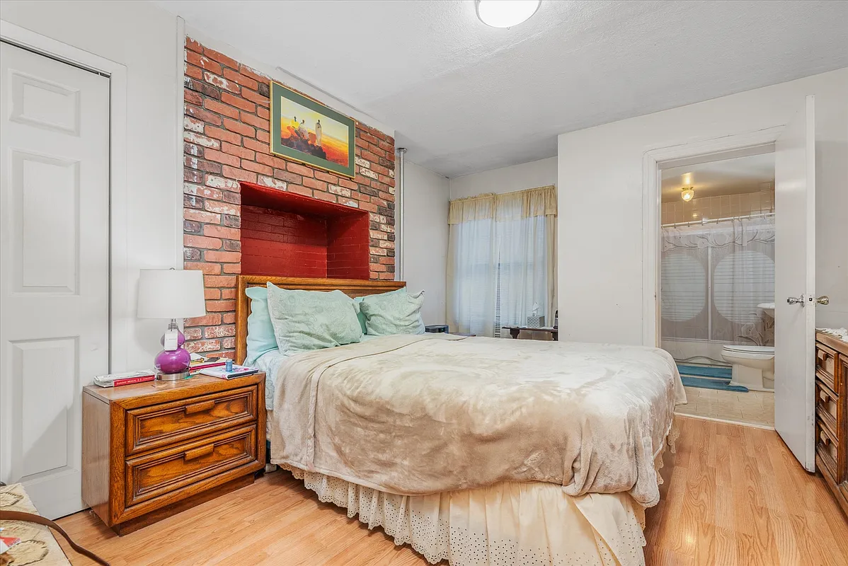 bedroom with exposed brick wall, en suite bath