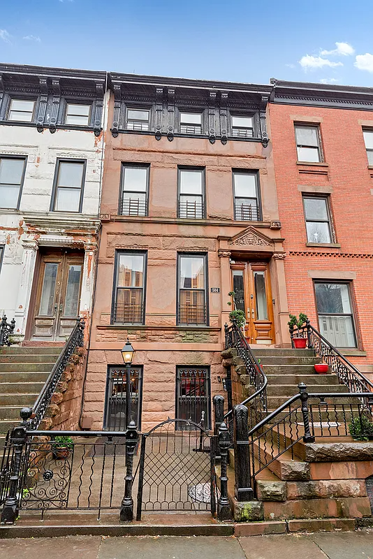 front facade of the brownstone with cast iron fence and railings up the stoop
