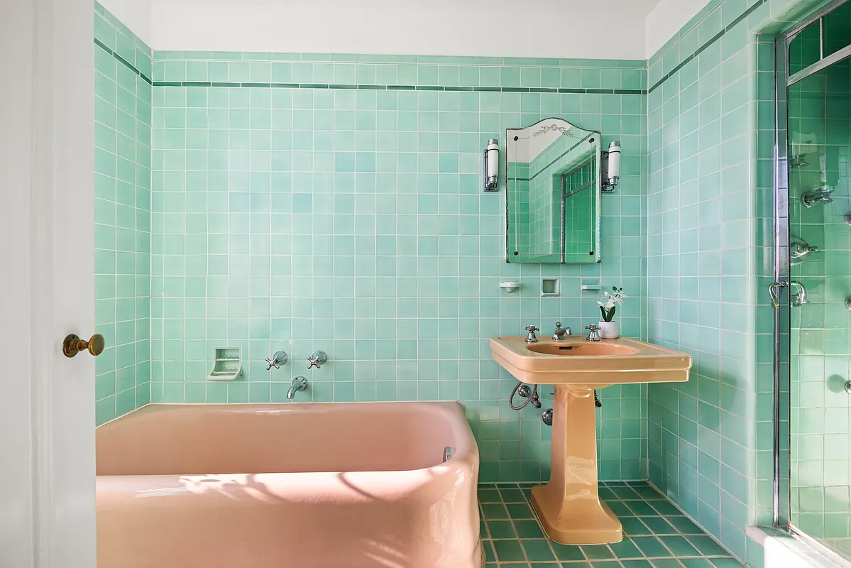 art deco bath with green wall and floor tile, a built-in shower, and a pink tub and sink