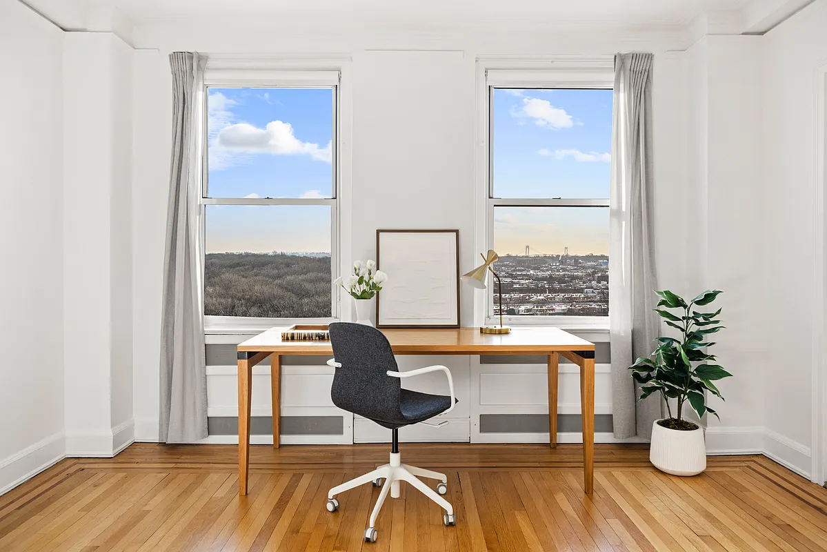 desk set up in front of windows with a view of the verrazzano bridge visible