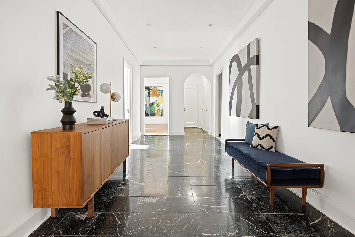 foyer with black marble tile floor, arched doorway to bedroom hall
