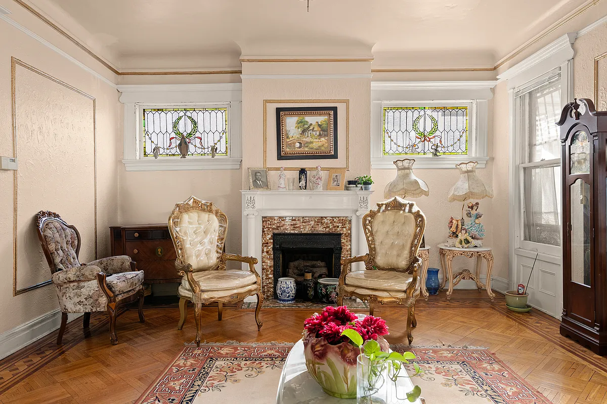 parlor with mantel, stained glass, wood floor