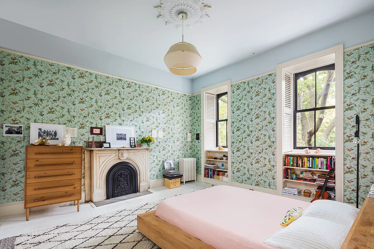 bedroom with wallpaper, mantel