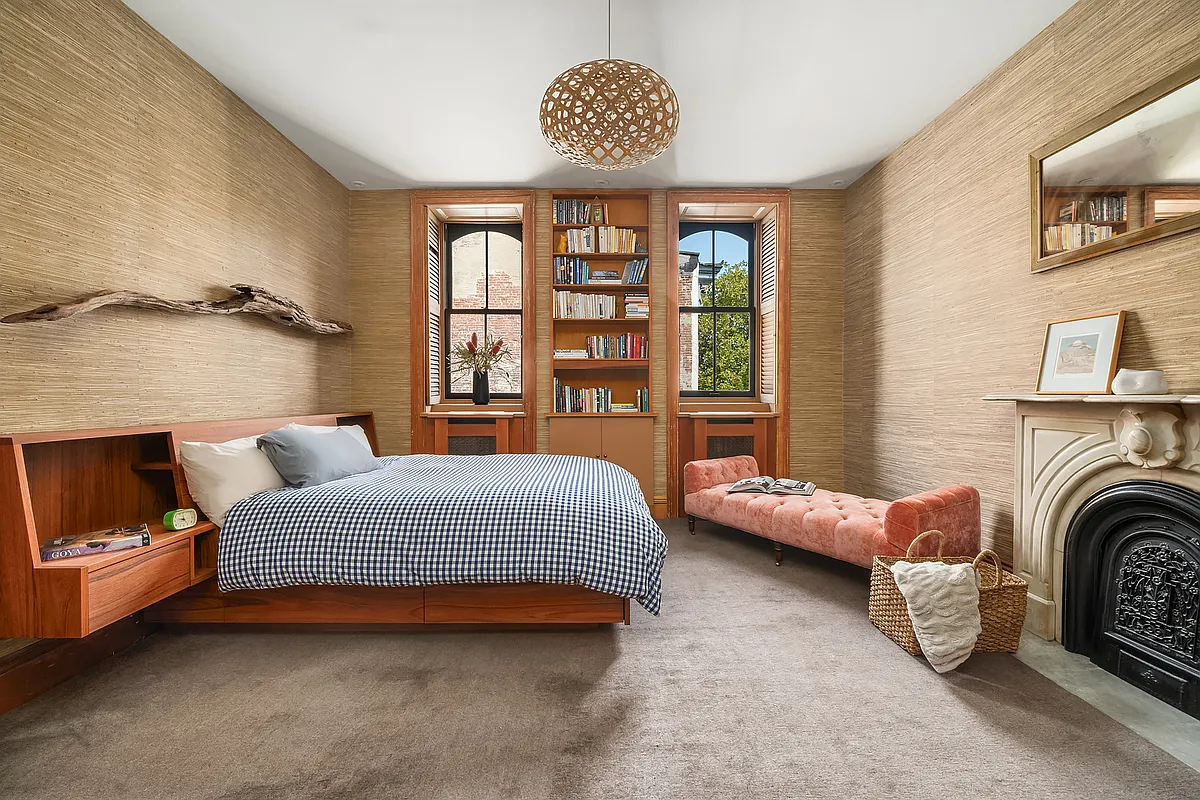 bedroom with carpet, mantel, neutral wall covering