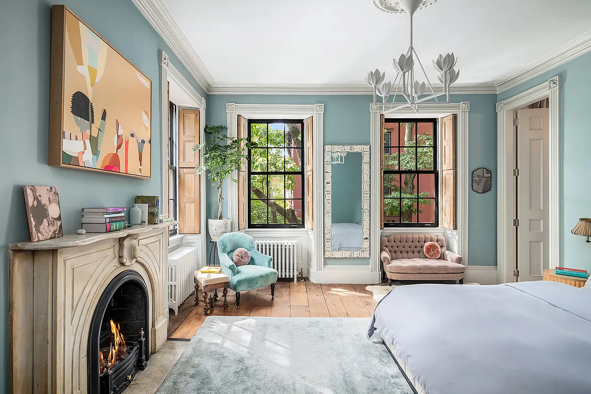 bedroom with mantel, wood floors