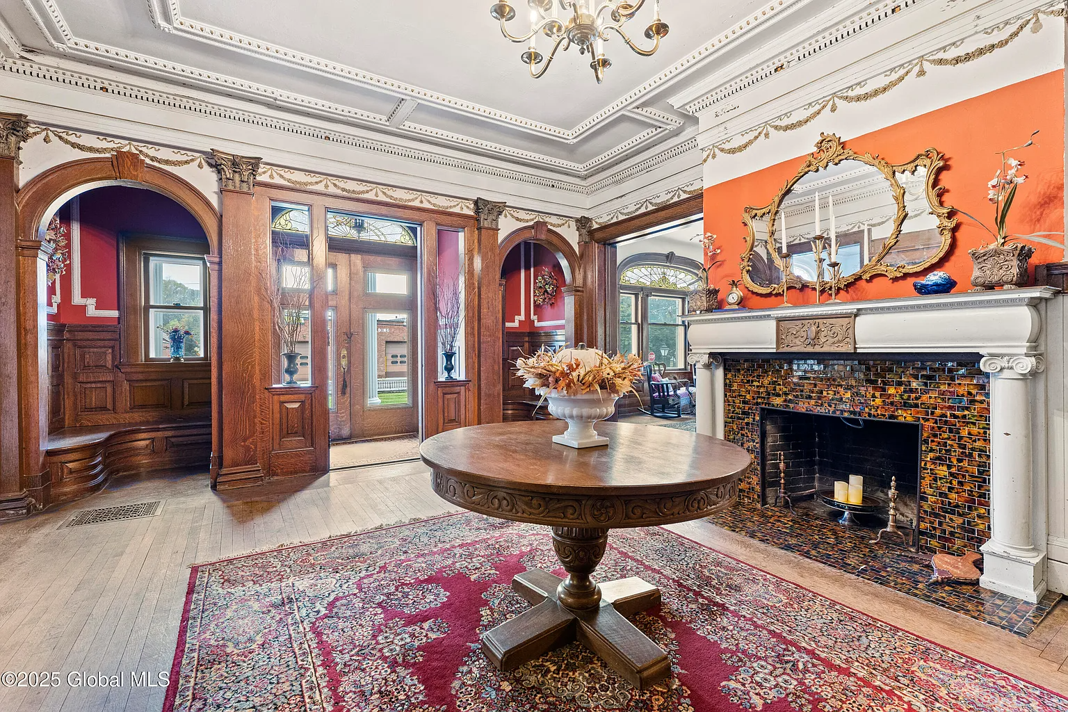 entry hall with arched nooks with benches, pilasters, mantel
