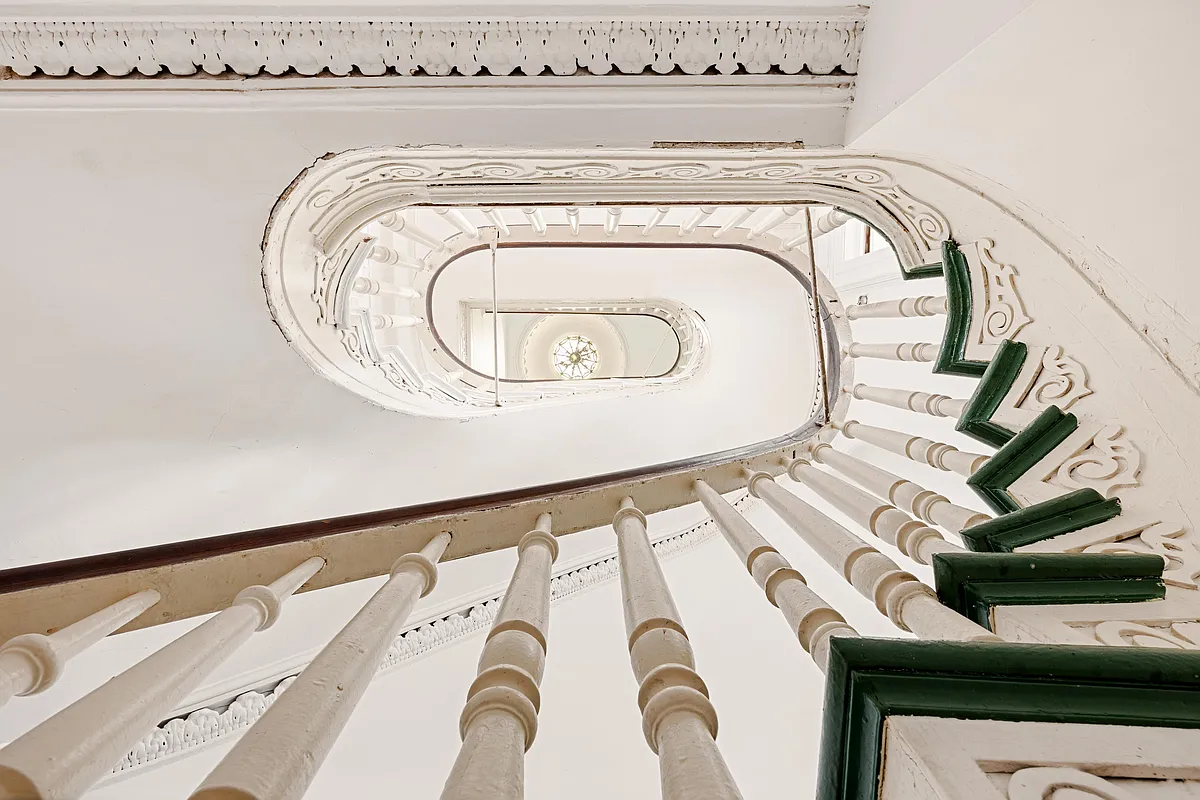 looking up the curved staircase with a view of the circular skylight at the very top