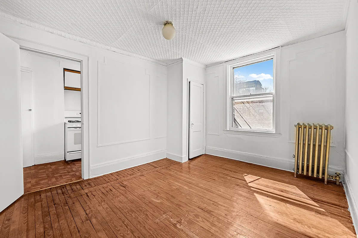 upper level room with wall moldings, tin ceilings and view into kitchen