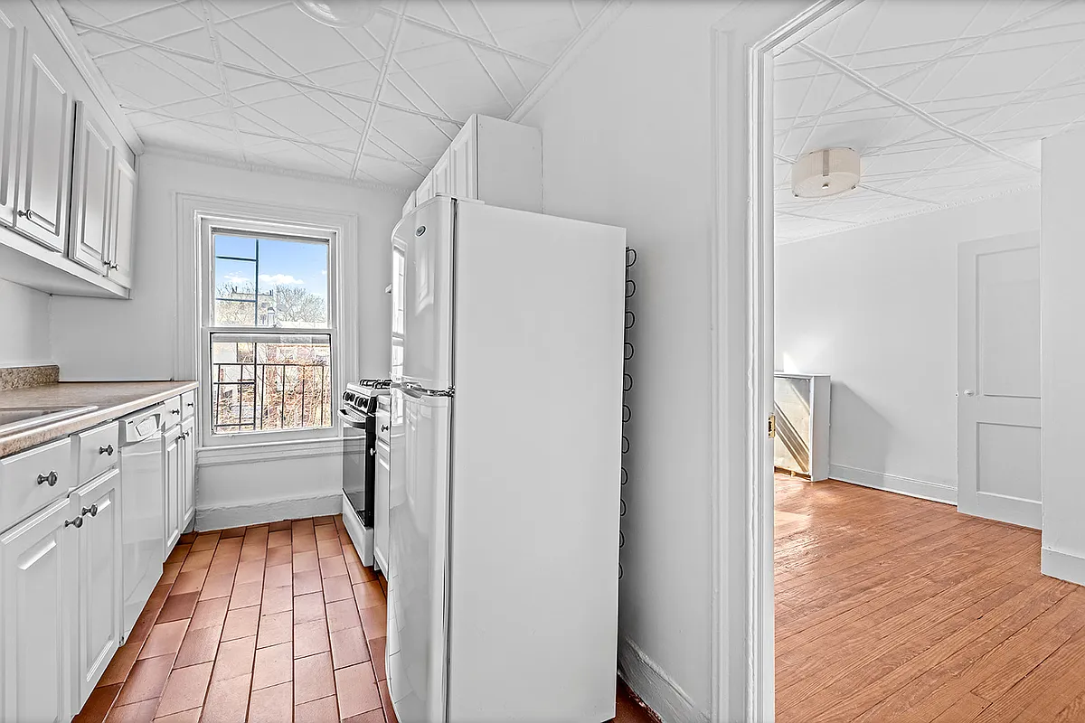 kitchen in upper unit with a tin ceiling and a tile floor