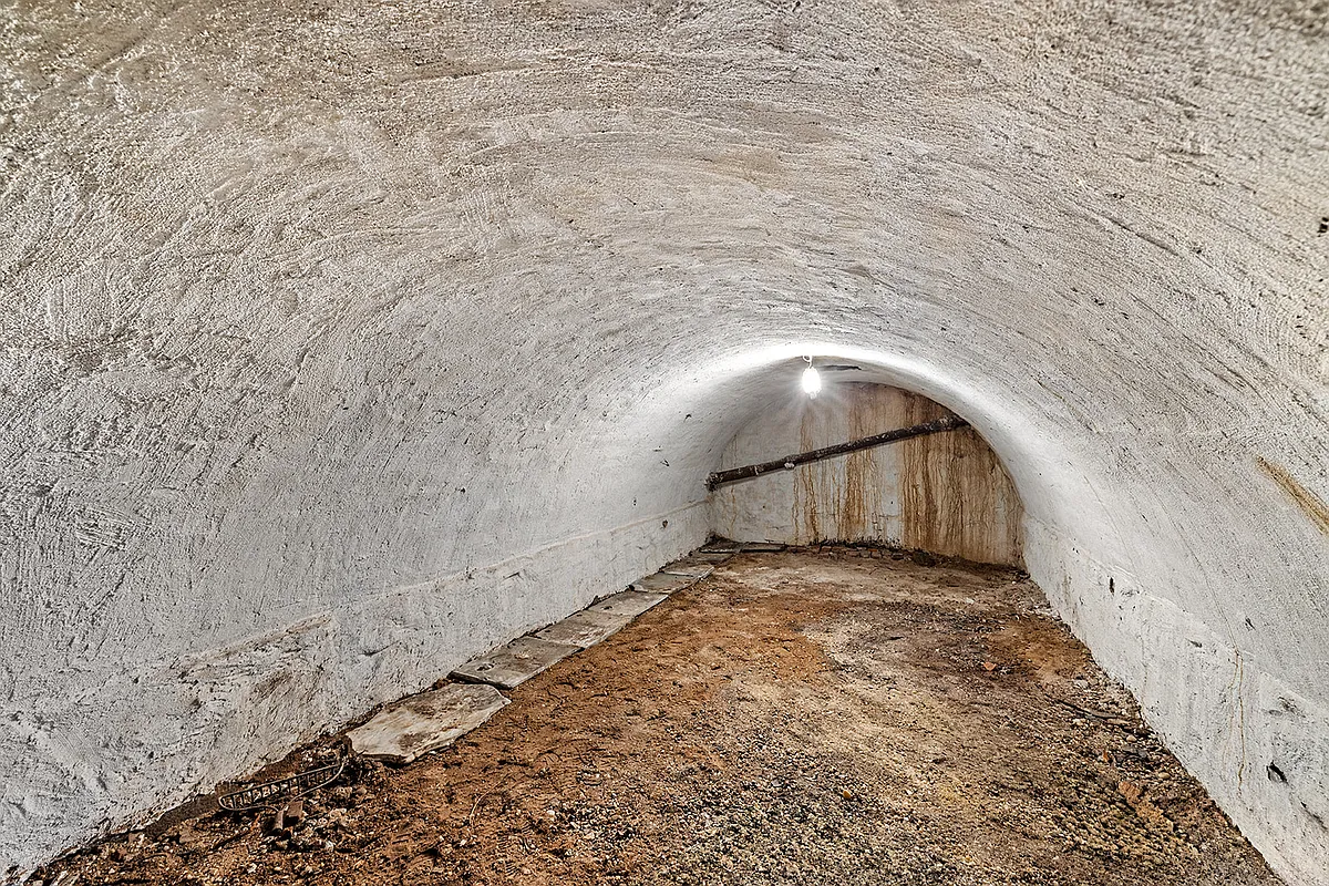 curved vault with dirt floor and white walls