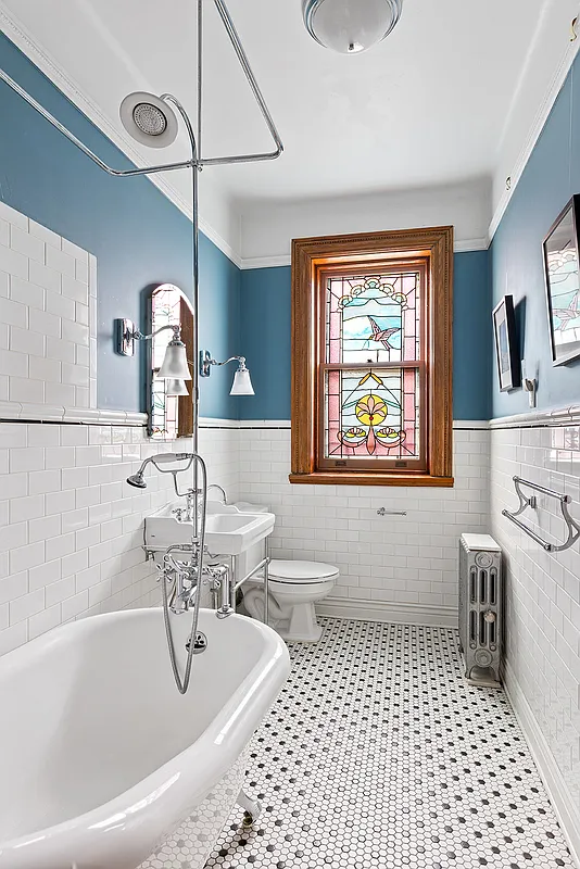 bathroom with clawfoot tub, stained glass window