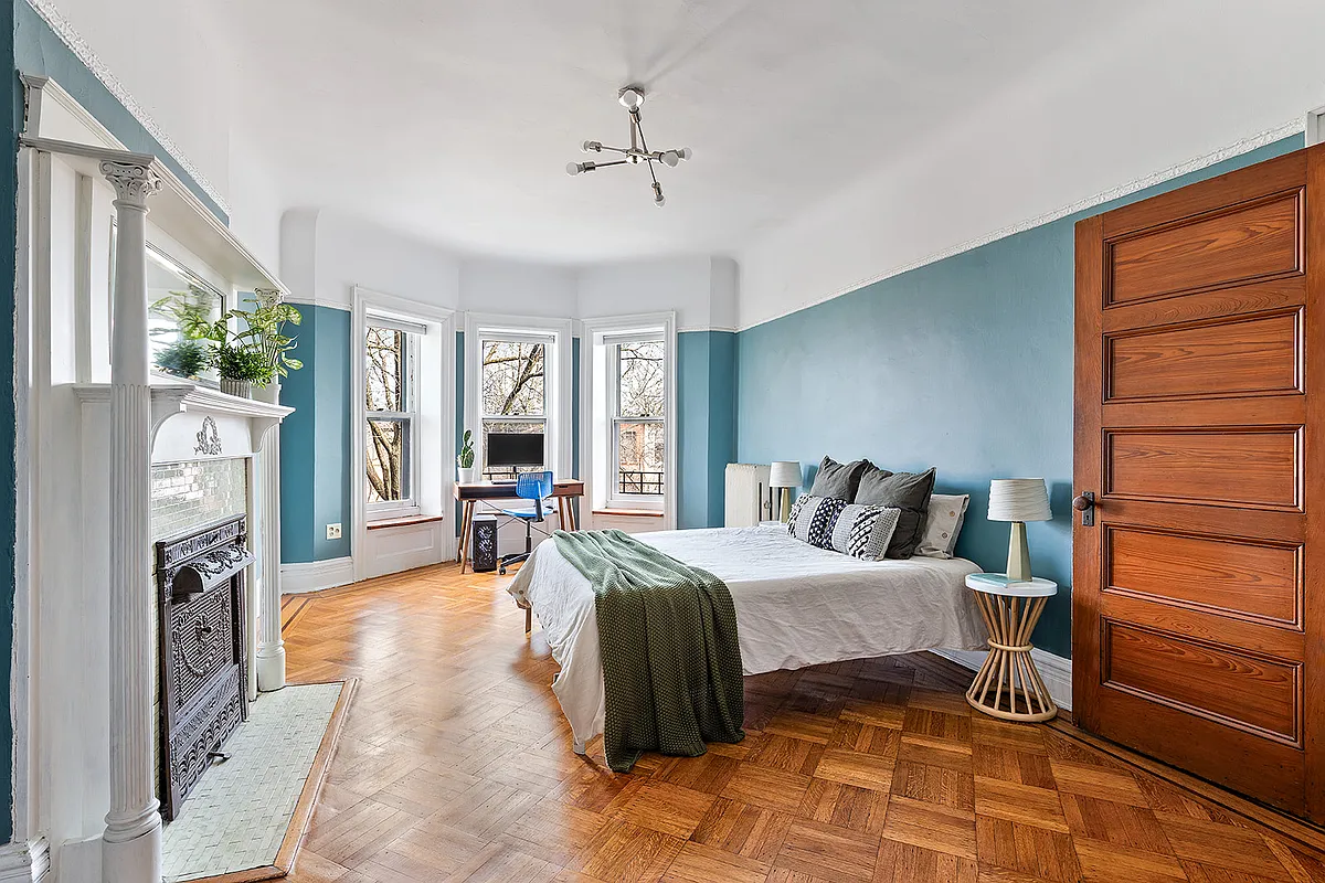 bedroom with wood floor, mantel