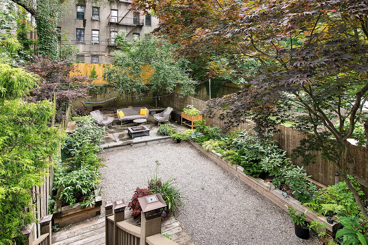 landscaped rear yard with planters, raised patio, gravel