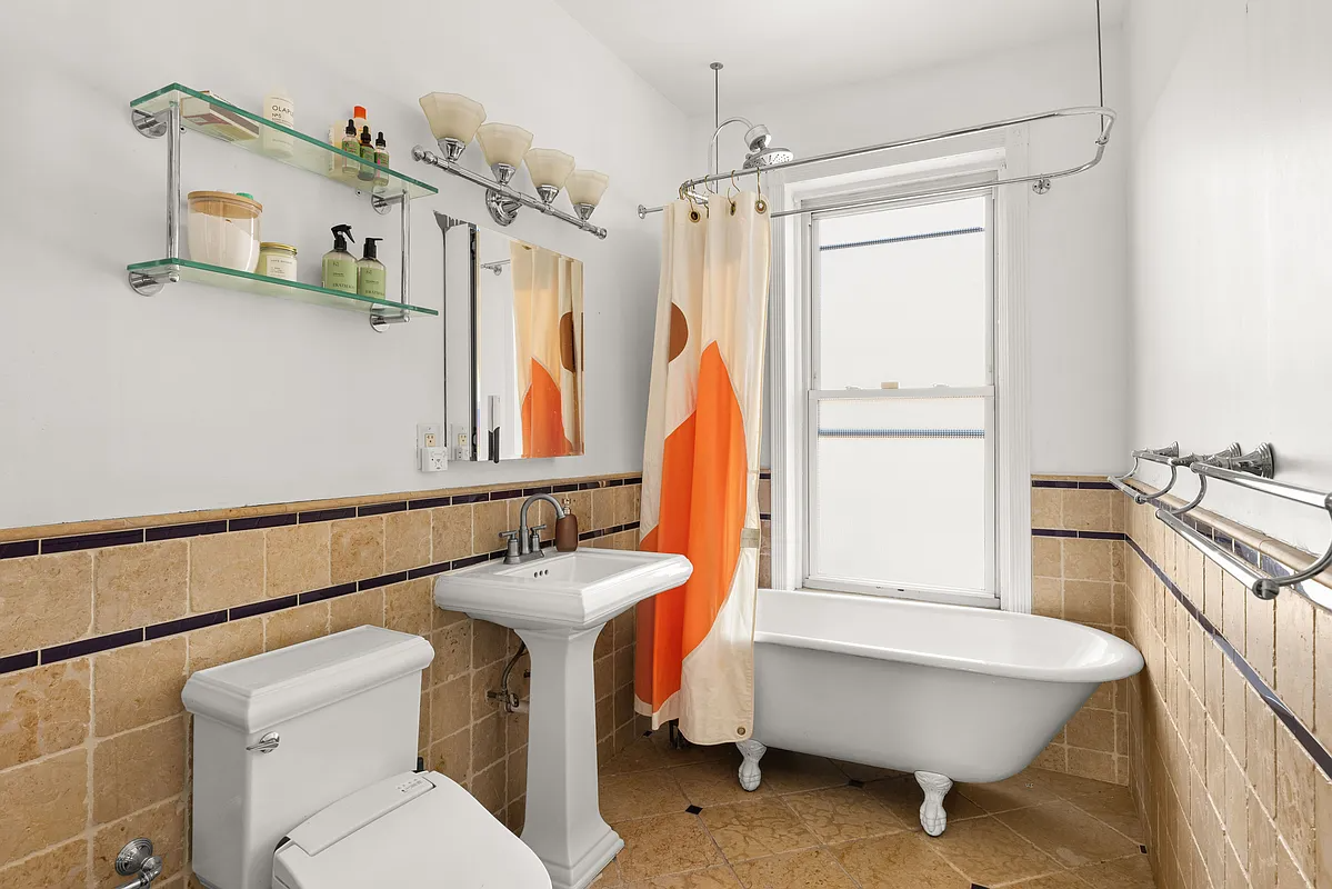 bathroom with clawfoot tub, brown tile