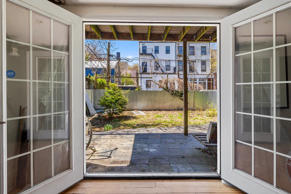 modern french doors open to a stone patio and yard