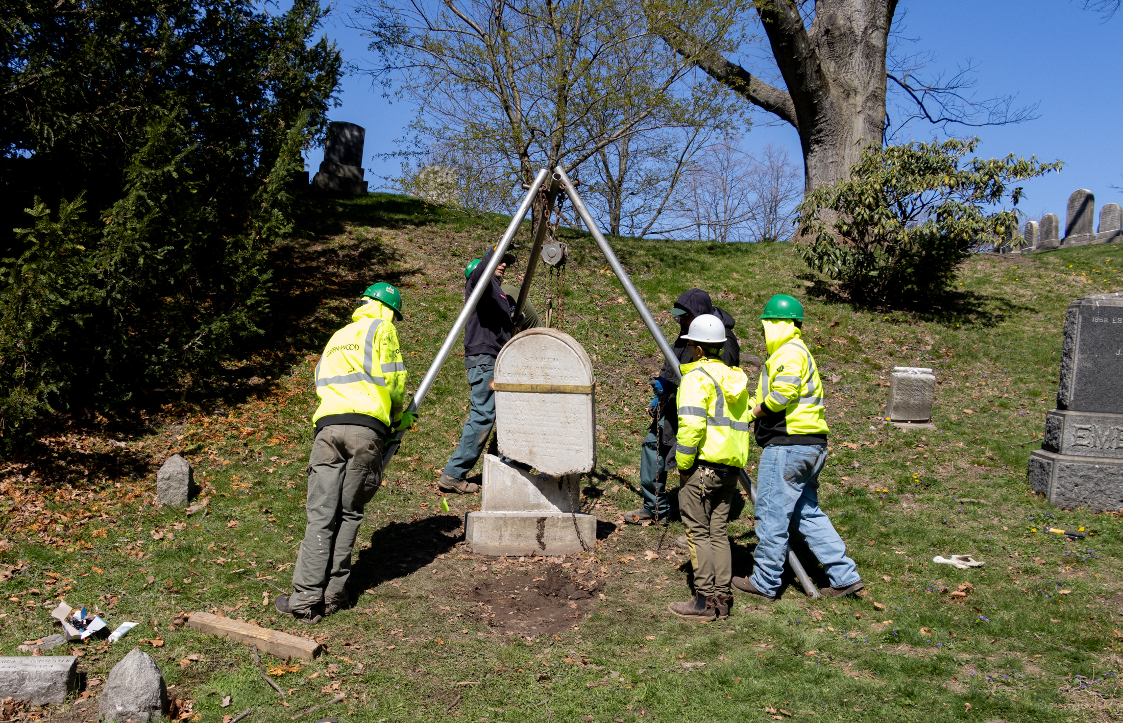 Students in the Workforce Development Program at Green-Wood cemetery hoist a gravestone into place.