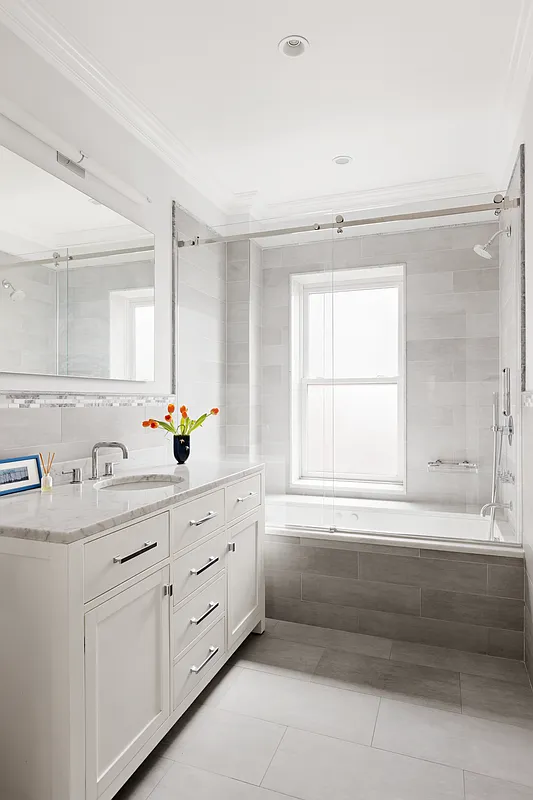 bathroom with white vanity, gray tile