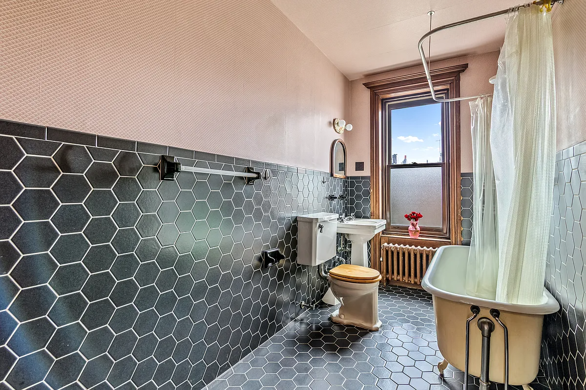 bathroom with claw foot tile, oversized black hex tile on floor and walls
